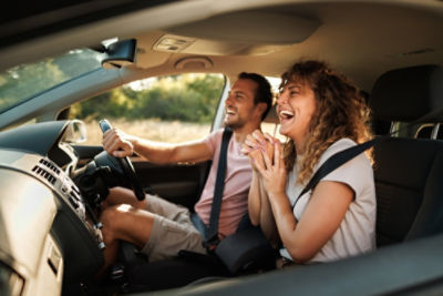 Female hugging a car with yellow hand bag and phone in her hand