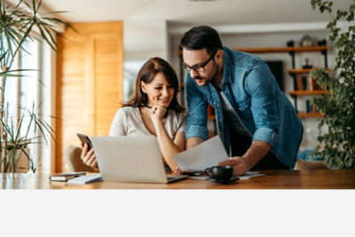 Family in kitchen looking at laptop