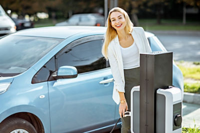 Woman charging electric vehicle