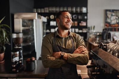 A business owner wearing an apron sitting in a flower shop