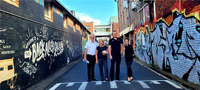 Staff members from CBA Lismore stand and smile outdoors