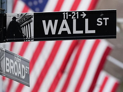 Wall street sign in front of US flags. Credit: AAP image