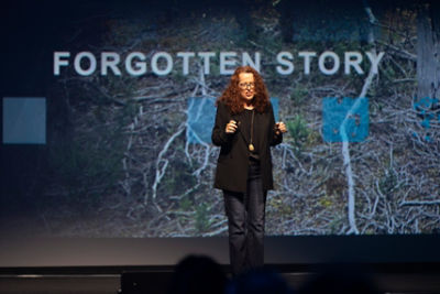 Presenter lady standing infront of momentum crowd for 2025