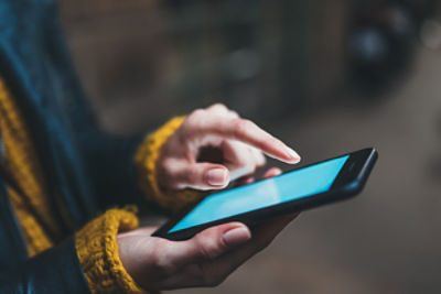 right side angled view of person holding a smart phone with the screen turned on