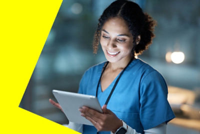Smiling woman in a medical uniform holds a mobile tablet
