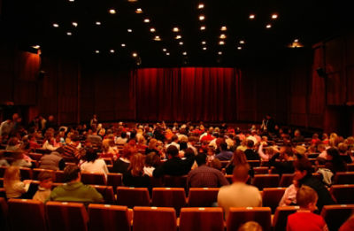 An audience in a movie theatre before the show begins. Credit: Adobe Stock