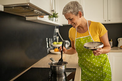 Woman cooking on induction cooktop