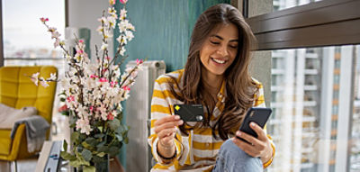 Women looking at the phone and holding the credit card