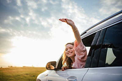 Woman waving from a car window