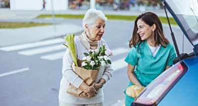 Female hugging a car with yellow hand bag and phone in her hand