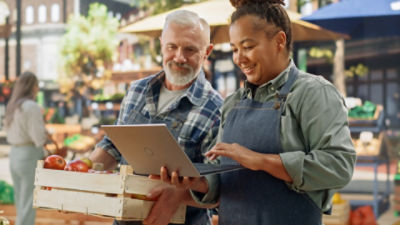 Business partners working on laptop at farmers market