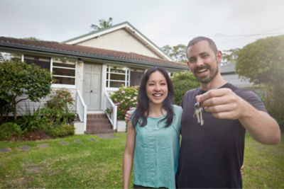 Couple outside house holding keys