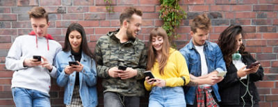 A group of young people with their phones. Credit: Adobe Stock