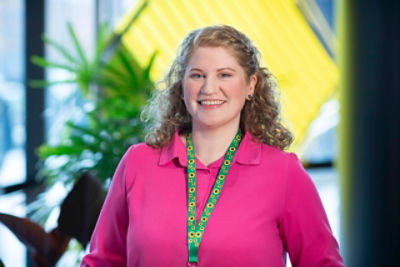 Woman smiling wearing the Hidden Disabilities Sunflower lanyard