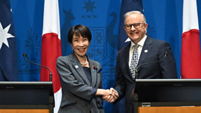 The leaders of Japan and Australia shaking hands. Credit: AAP photos