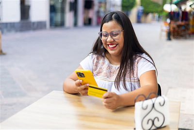 Women looking at the phone and holding the credit card