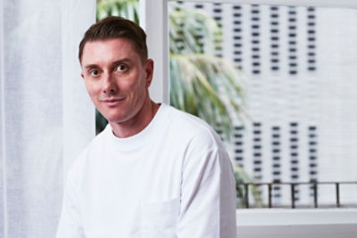 Simon Davies sitting with a window behind him.