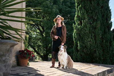 Lisa Harper standing in a courtyard with a dog beside her.