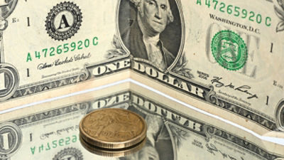 A US dollar note and Australian dollar coin. Credit: AAP