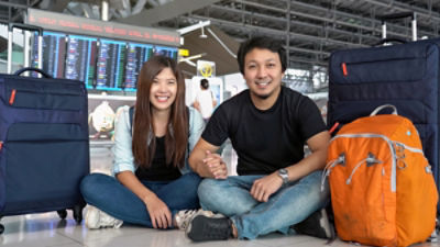 Tourists seated with their luggage at an airport: Credit Adobe Stock