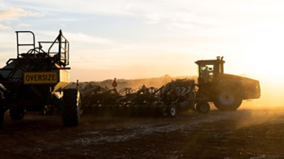 Tractor and air seeder planting wheat at sunset. Credit: Austockphoto