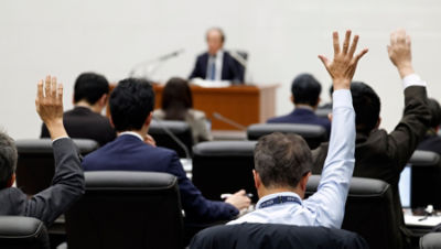 Journalists raise their hands to ask questions to Bank of Japan (BOJ) Governor Kazuo Ueda during a press conference at the bank's headquarters in Tokyo.