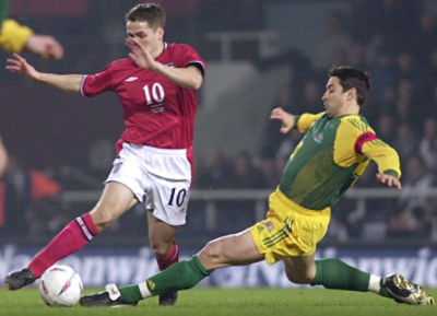 Australia's captain Paul Okon, right, tackles England's Michael Owen during their friendly International soccer match at the Upton Park stadium in London, Wednesday, Feb. 12, 2003. (AP Photo/Richard Lewis)