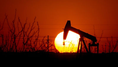 A pump jack operates as the Sun begins to set on the western horizon Monday, March 7, 2022, near Pleasant Farms, an unincorporated community in southeastern Ector County, Texas. Oil prices are rising sharply again Tuesday as the U.S. prepares to ban crude oil imports from Russia in response to that country's unprovoked invasion of neighboring Ukraine. (Jacob Ford/Odessa American via AP)