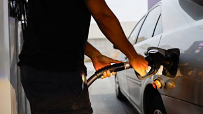 Member of the public filling their car with petrol at a service station.