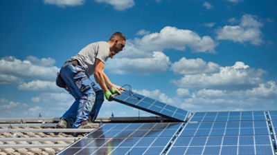 Solar panel technician installing solar panels on roof. Picture credit: mmphoto