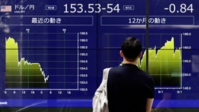 A passerby looks at a monitor showing the foreign exchange rate between the US dollar and the Japanese yen in Tokyo, Japan. Credit: EPA