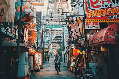A person riding a bicycle through the narrow streets of Osaka