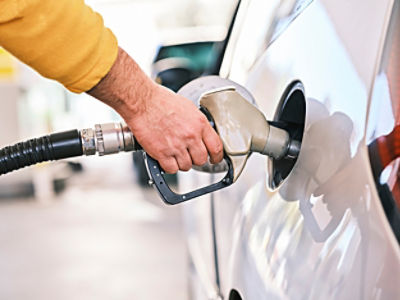 A hand pumping petrol into a car. 