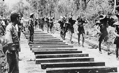 Prisoners of war carrying railway sleepers in Burma in 1943 (Australian War Memorial P00406.026)