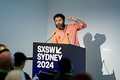 Saul Griffith speaking at a lectern at SXSW Sydney 2024.