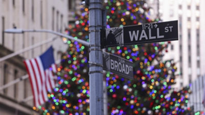 The Wall Street sign in front of a decorated Christmas Tree and a US flag. Credit: AAP