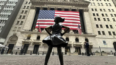 The fearless girl statue in front of the New York stock exchange and a US flag. Credit: AAP