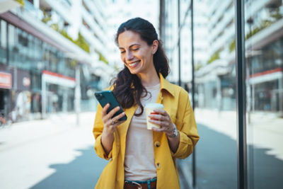 woman drinking coffee looking at phone 