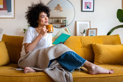 Waman drinking coffee on sofa