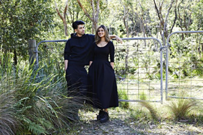 Quincy Lim and Krish Waje standing in front of a fence at their property in the Blue Mountains.